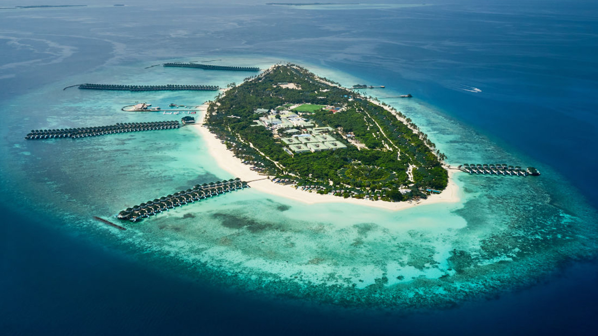 Aerial view of a Maldives resort with overwater villas